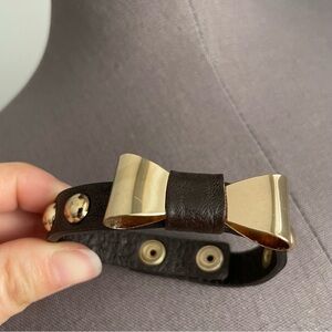 Gold bow with brown studded strap bracelet